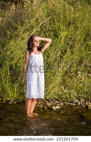 Beautiful woman at the river. Young woman goes barefoot through the mountain river in sunny weather.Enjoyment. Free Happy Woman Enjoying Nature. Beauty Girl Outdoor. Freedom concept