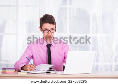 Student workplace computer. Young boy sitting at desk and looking at computer, thoughtfully addresses issues to prepare for the seminar. Study, student, training, youth - education concept.