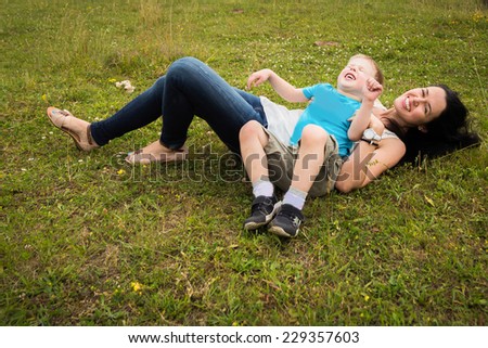 Mom and son in the summer field. Mother playing with her son. Mother and son having a great weekend. Games, field, family weekend - family-friendly concept. Article about the family.