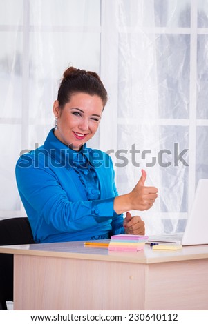 Woman in a business suit. Business woman sitting at the table, working with the computer. Business, work, business woman - business concept girl. The idea about the woman's business.