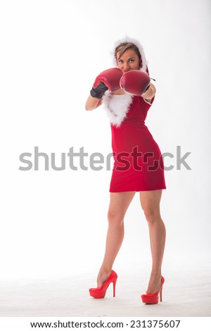 Seductive, athletic blonde in a New Year\'s suit and red boxing gloves. Sexy woman posing in boxing gloves on a white background. New Year\'s holidays, sports, boxing - New Year concept of fitness.