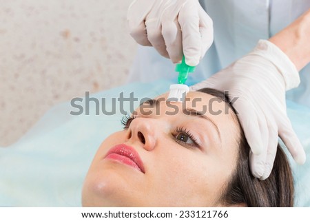 Young girl in a beauty parlor. Beautician spa facial treatment, a young girl. Application of peeling on the face, a special brush. Beauty, skin care, cream application - Concept facials.