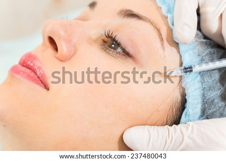 Cosmetic injection in the spa salon. Beautician makes injection into the patient\'s face. the concept of rejuvenation.
