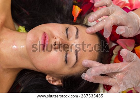 Beautiful woman in salon.Spa therapy for young woman receiving facial mask at beauty salon - indoors.Cosmetology, beautician, beautiful background - concept of a facial care.