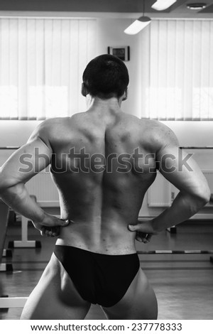 The man in the gym, posing, showing his muscles. Force, relief, muscle, courage, virility, bodybuilder, bodybuilding - the concept of a healthy lifestyle.