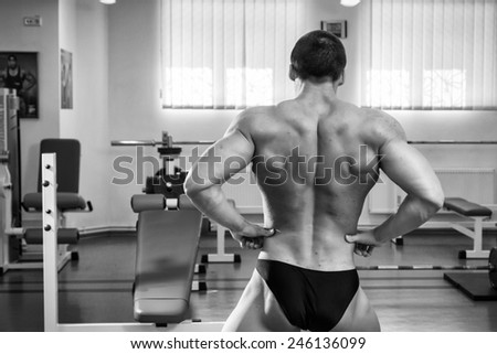 Bodybuilder showing his muscles. Muscles of the back, arms, torso. Muscular man in great shape. The concept of bodybuilding.