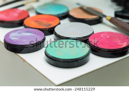 Make up palette with different colors. Brush makeup lying on pallets with different colours.