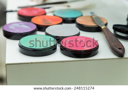 Make up palette with different colors. Brush makeup lying on pallets with different colours.