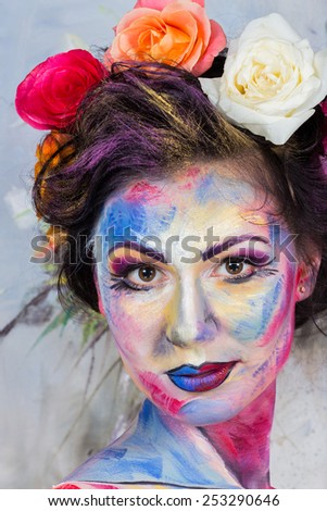 The creative, bright, color makeup. Floral makeup. Art makeup. Tone, powder, make-up. Multi-colored roses in her hair girl. Creative floral make-up on the model, background floral pattern.