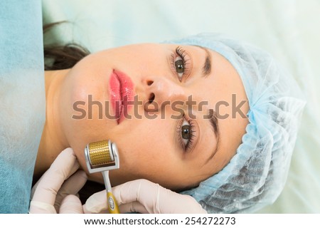 Medical cosmetic procedure. Mikronidling. Beautician performs Dermaroller procedure.young beautiful woman having an injection mesotherapy.cosmetic procedures in spa clinic.