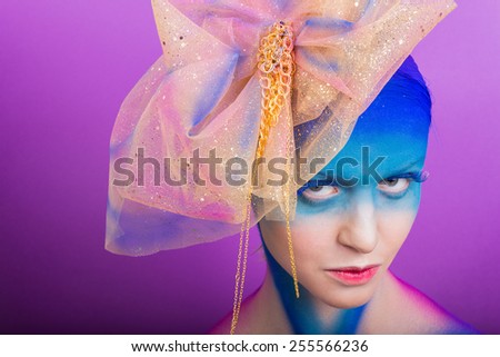 Creative makeup. Airbrush. Blue, indigo, violet makeup. Seasoned professional creative eye make-up, hair. Golden headdress on the girl.