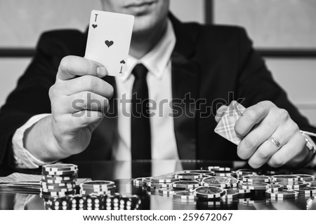 The concept of card games. Man playing poker at the poker table. Playing chip cards and whiskey on the table