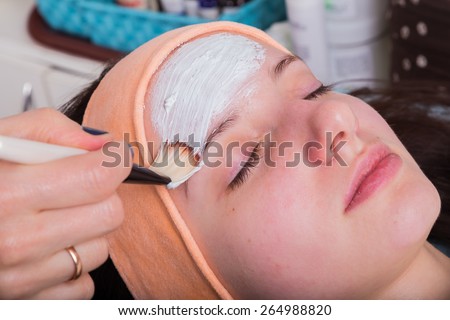 Cosmetic procedures for the face. The application of the mask on the face of a young girl. Facial Skin Care.