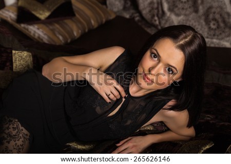 Portrait of a beautiful brunette. Girl lying in the bedroom. positive emotions.