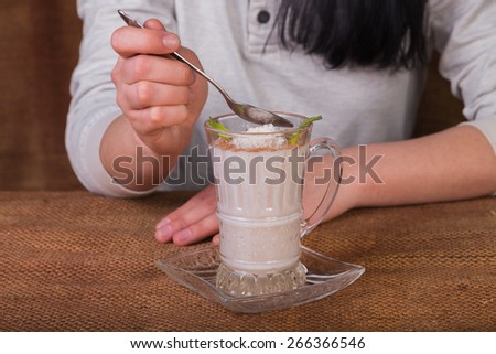 Woman eating dairy dessert spoon. The Dessert. Dessert based on milk and coffee.