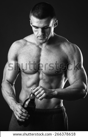 Male bodybuilder shows that beer is bad. Unhealthy eating habits. If you want to be healthy and strong do not drink beer.