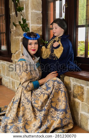 Mother and son in medieval costumes, in a beautiful interior. Costume photo session.