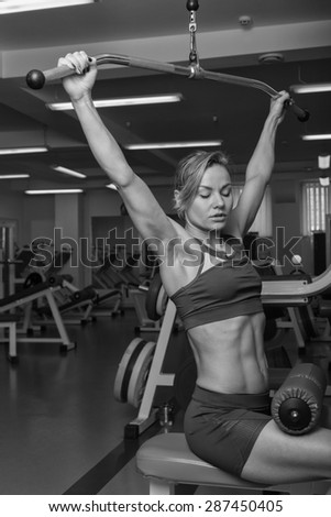 Strong young woman doing shoulder press with dumbell Stock Photo