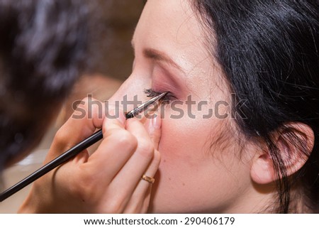 Makeup artist apply makeup to a model.