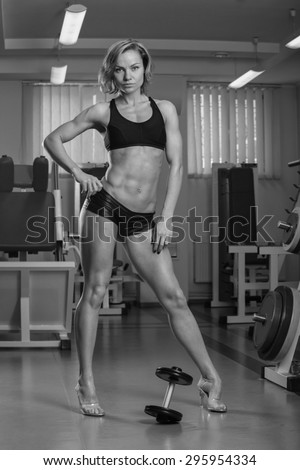 Girl pumps the major muscle groups in the gym. Strength training. Female fitness. Strong girl.