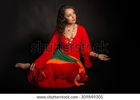 Brunette with gypsy dress. Traditional Gypsy women\'s accessories and dresses. Emotions and gypsy flavor. Gypsy on a black background.