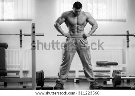 The athlete in the gym. Professional weightlifting. Weight training. Work on tell muscles. The success achieved by effort.