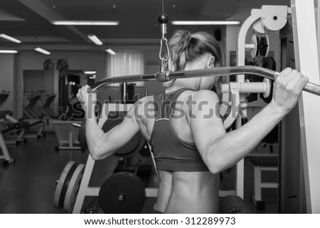 Blonde in the gym. Weight training. Work on the muscles of the back. Dumbbell bench press and pull on poperechchyni. Shaping tell muscles of the back. Women\'s fitness.
