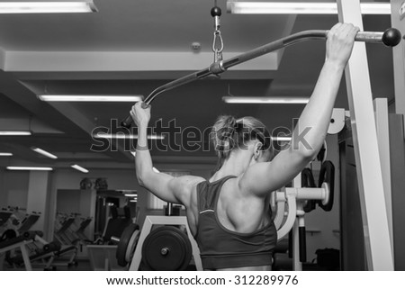 Blonde in the gym. Weight training. Work on the muscles of the back. Dumbbell bench press and pull on poperechchyni. Shaping tell muscles of the back. Women\'s fitness.