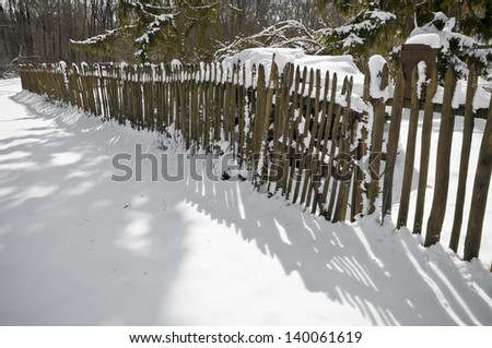 Old fence and shadow with snow at Ocsa landscape protection area (Ocsai tajvedelmi korzet), Hungary.