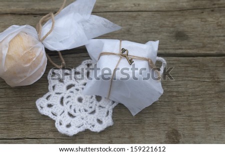 gifts in the paper and crocheted snowflake on the old board