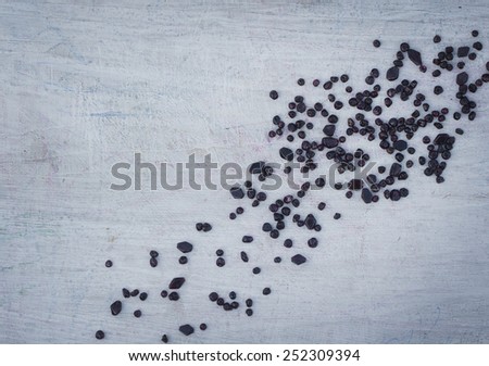 scattered on the wooden white Board dark beads for the background