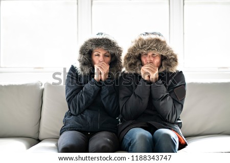 Couple have cold on the sofa at home with winter coat Stock foto © 