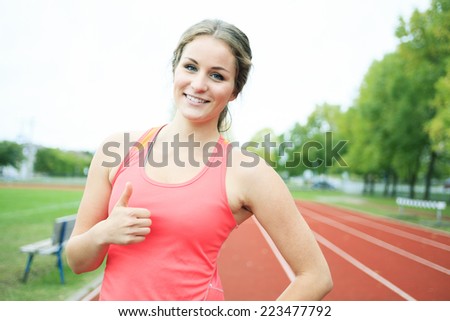 Positive young woman jogging track