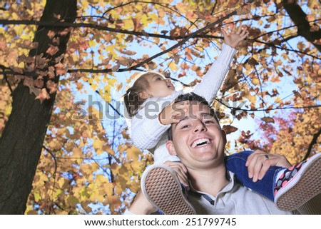 A Family enjoying golden leaves in autumn park