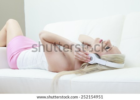 Young attractive girl listening to the music in modern interior