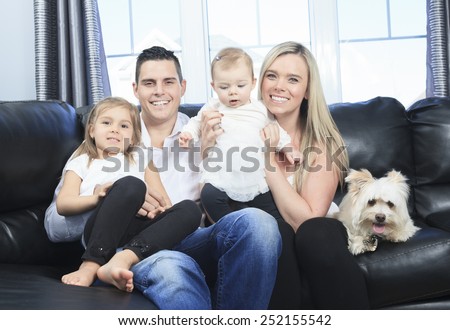 A Family with pets sit on sofa at home
