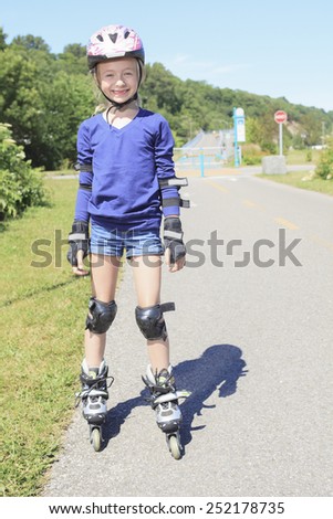 A Little girl in roller skates at a park