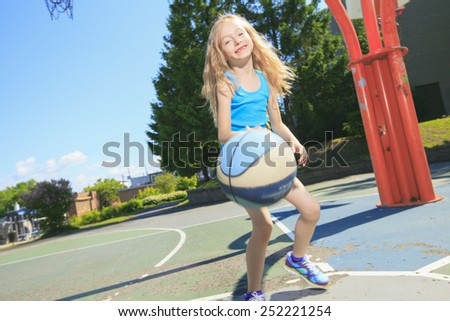A little girl play basketball with on the playground
