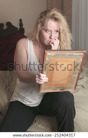 A sad woman take a look on picture frame