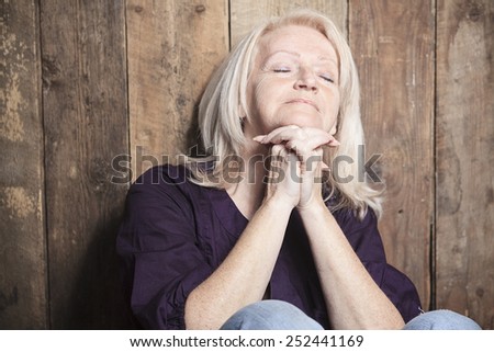 A senior person pray with a wood background