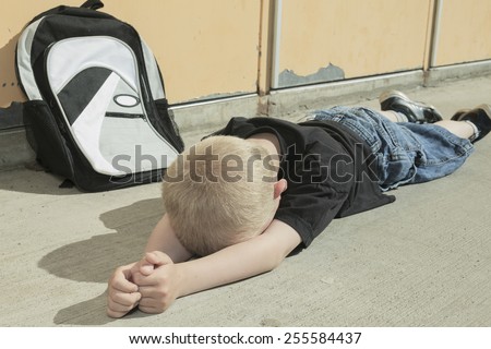 A very sad boy bullying in school playground.
