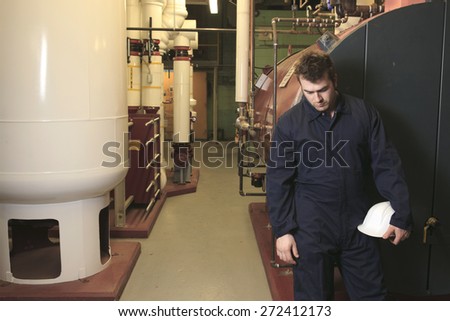 maintenance engineer checking technical data of heating system equipment in a boiler room