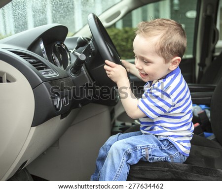 Cute little boy driving fathers car