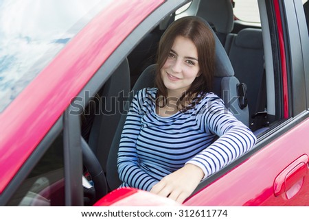 A Woman driver who is happy to have is new car