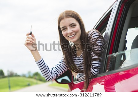 A Woman driver who is happy to have is new car