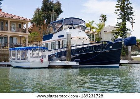 Beautiful boat moored outside the back yard of a waterfront house in Newport Beach, California, USA.