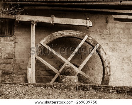 Old mill water wheel without water, no motion, sepia image