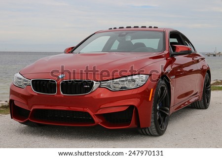 TAMPA, FLORIDA/USA - JANUARY 18 2015: The brand new 2015 BMW M4 parked near a beach in Tampa, FL. This Sakhir Orange M4 has a 6 cylinder twin turbo engine as well as the upgraded 19 inch black wheels.