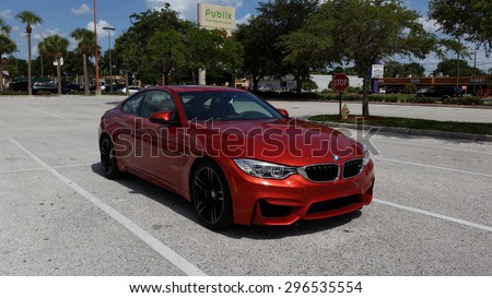 TAMPA, FLORIDA/USA - July 10 2015: A new 2015 BMW M4 parked in a Publix parking lot in Tampa, FL. This Sakhir Orange M4 has a 6 cylinder twin turbo engine as well as the upgraded 19 inch black wheels.