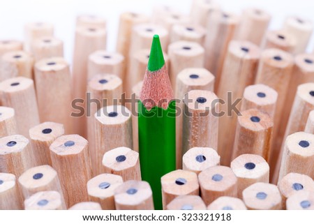 One sharpened green pencil among many ones